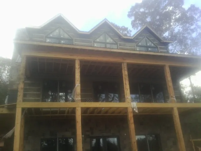 Dormers and porch framing on a large log home under construction — Roof Coating work by our crew in Lykens